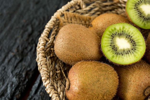 Kiwifruit in de mand op zwarte houten lijst