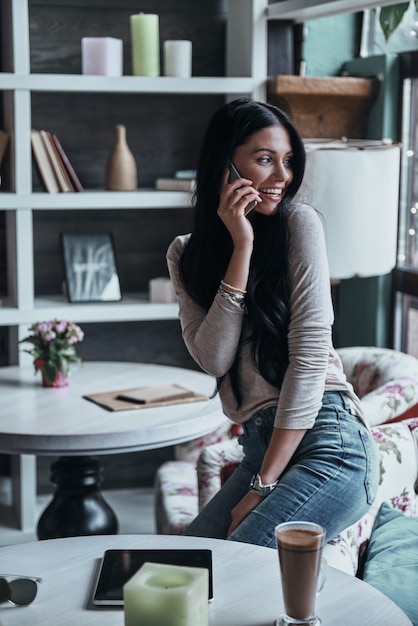 klaar om elk moment te helpen. aantrekkelijke jonge lachende vrouw praten op slimme telefoon