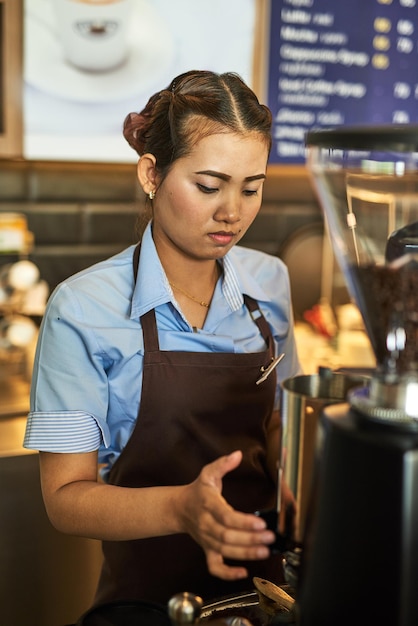 Klaar om je cafeïnekick op te dienen Shot van een gefocuste jonge barista die achter de kassa in een coffeeshop werkt