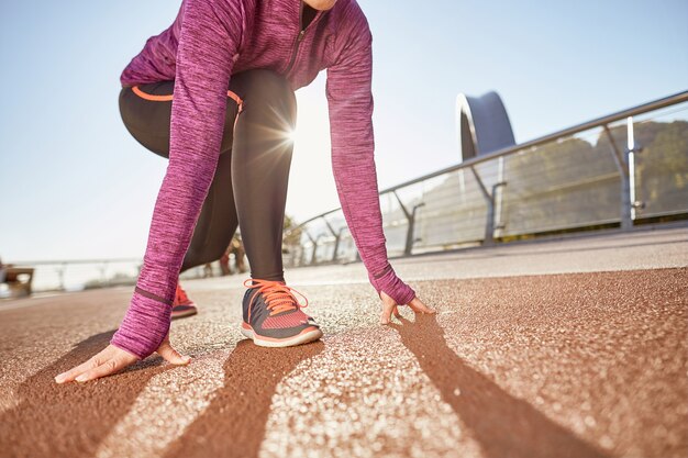 Klaar om te gaan bijgesneden opname van actieve volwassen vrouw die sportkleding draagt en klaar staat in startpositie