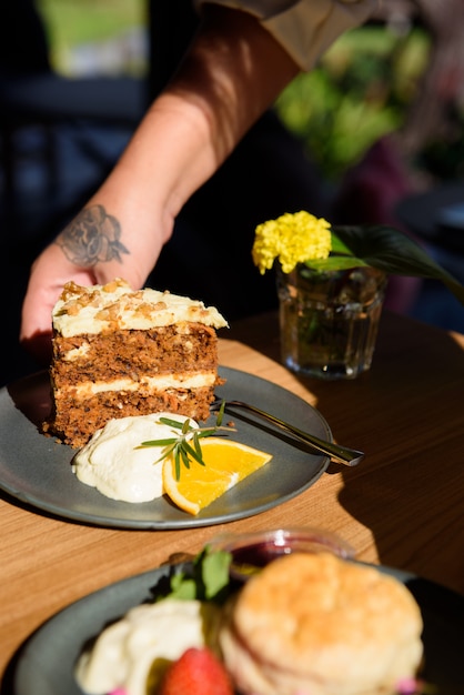 Klaar om te serveren, Cake, Chinmon gemengde chocolade, Schik het gerecht met slagroom en sinaasappel, Houten tafelblad.