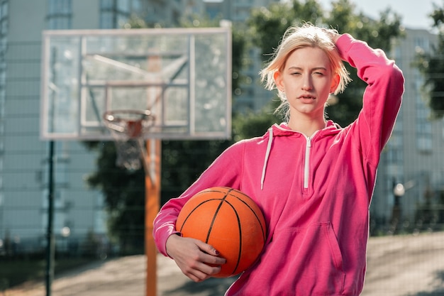 Klaar om te spelen. Leuke blonde vrouw die haar hand op het hoofd legt terwijl ze klaar is om te spelen