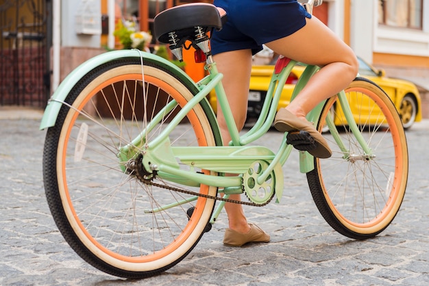 Klaar voor een ritje. Close-up van een jonge vrouw die fietst langs de straat