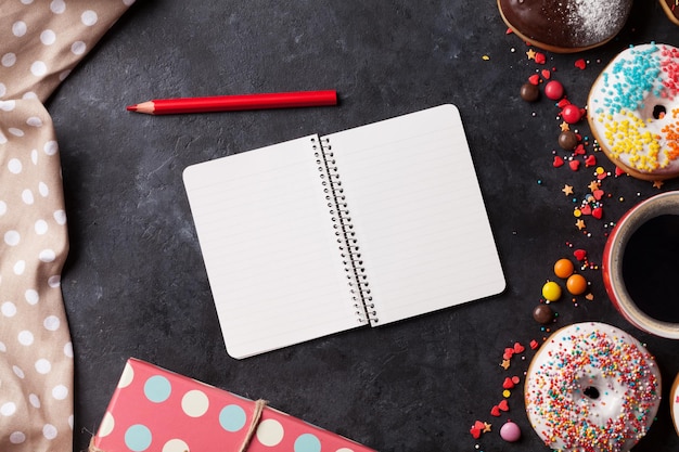 Kladblok donuts en koffie op stenen tafel