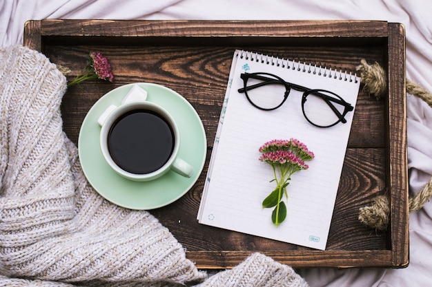 Kladblok en een kopje koffie op een dienblad