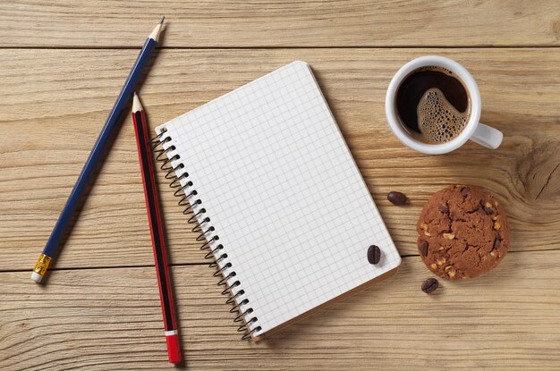 Kladblok en koffie met koekjes