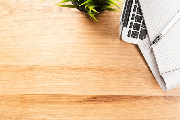 Kladblok en laptop op houten tafel