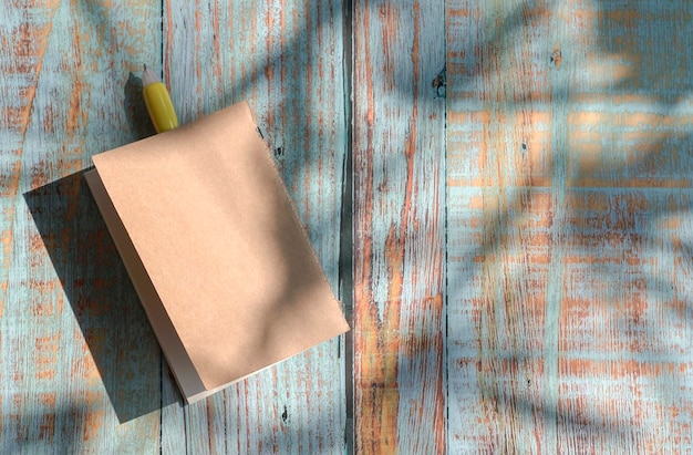 Kladblok met gele pen bovenop rustieke houten tafel