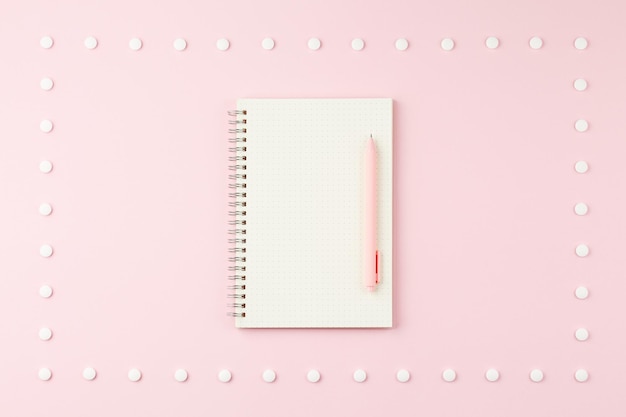 Kladblok met pen op roze bureau