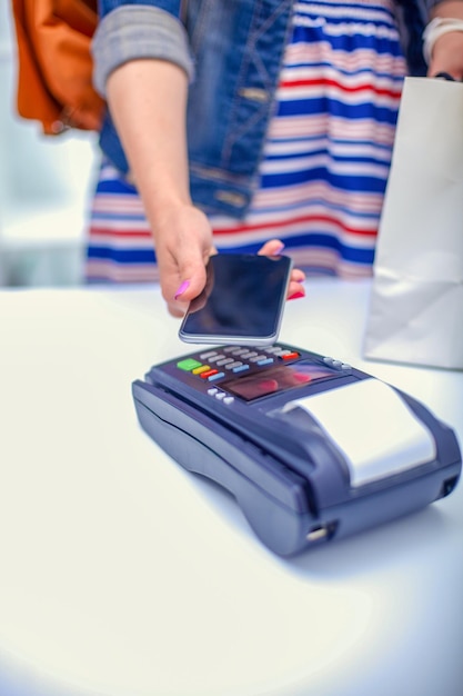 Klant betaalt met smartphone in winkel met NFC-technologie NFC-technologie Klant betaalt