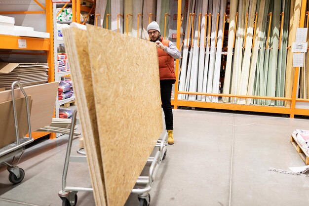 Foto klant die osb-panelen inspecteert in een winkel voor reparatiebenodigdheden