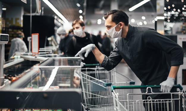 Klant in beschermende handschoenen die producten in een supermarkt kiest. hygiëne en gezondheidszorg