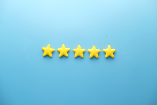 Foto klantbeoordeling concept. rating gouden sterren op blauwe achtergrond