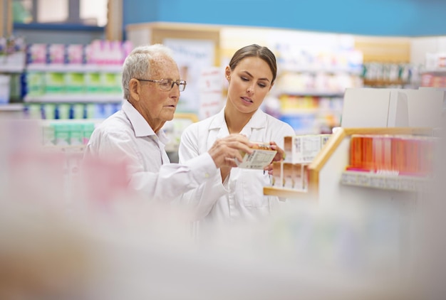 Klanten voorzien van alle feiten van een jonge apotheker die een oudere klant helpt