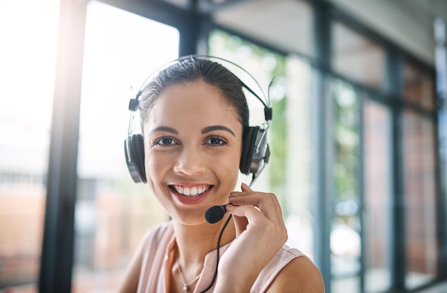 Foto klantenondersteuningsportret en vrouwelijke callcenterconsulent die werkt aan online consultatie op kantoor neem contact met ons op headset en gezicht van vrouwelijke telemarketingagent met crm-communicatie op de werkplek