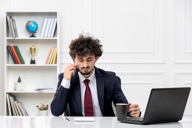 Klantenservice knappe jonge kerel in kantoorpak met laptop en headset aan het bellen