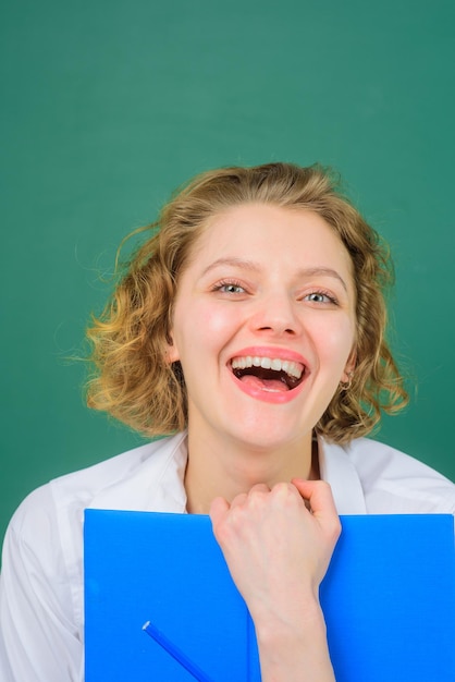 Klas dagboek terug naar school lachende leraar met klas dagboek gelukkige leraar schoolvakken pen