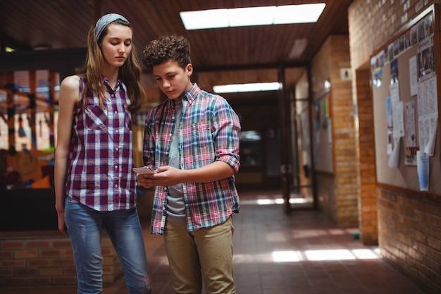 Klasgenoten met behulp van mobiele telefoon in gang op school