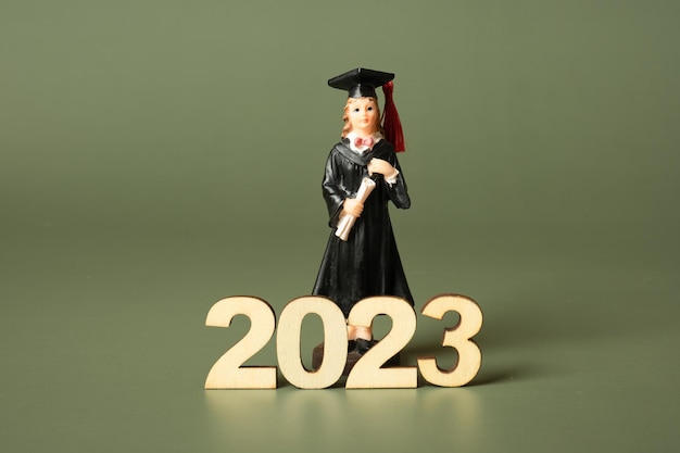 Klasse van 2023-concept Houten nummer 2023 met gediplomeerd beeldje op gekleurde achtergrond