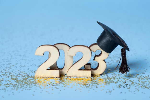 Klasse van 2023 concept Houten nummer 2023 met gegradueerde dop op gekleurde achtergrond