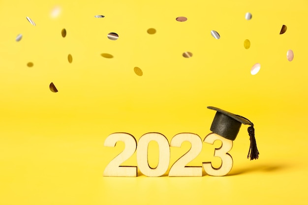 Klasse van 2023 concept houten nummer 2023 met gegradueerde dop op gekleurde achtergrond