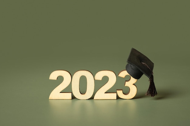 Klasse van 2023 concept Houten nummer 2023 met gegradueerde dop op gekleurde achtergrond