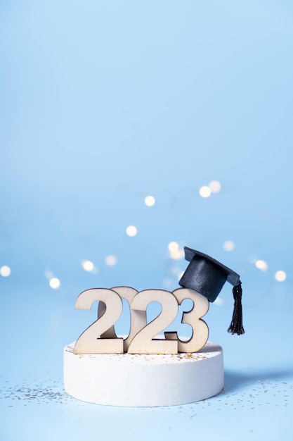 Klasse van 2023 concept Houten nummer 2023 met gegradueerde dop op podium op gekleurde achtergrond