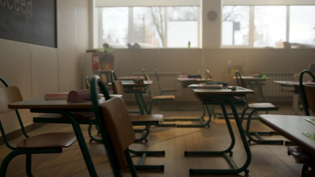 Klassenlokaal met bureaus en stoelen Interieur van de schoolkamer met krijtbord