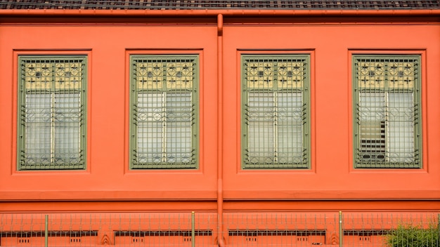 Klassiek groen houten venster bij het oranje concrete gebouw