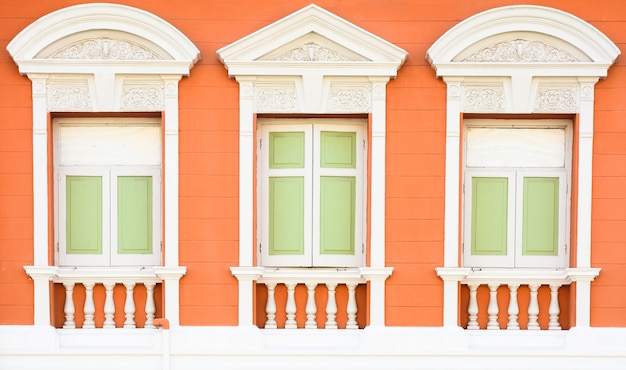 Klassiek houten venster bij het oude oranje concrete gebouw