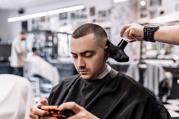 Klassiek kapsel in een kapperszaak. Curve haarstyling en haarverzorging in een kapperszaak. Mannen