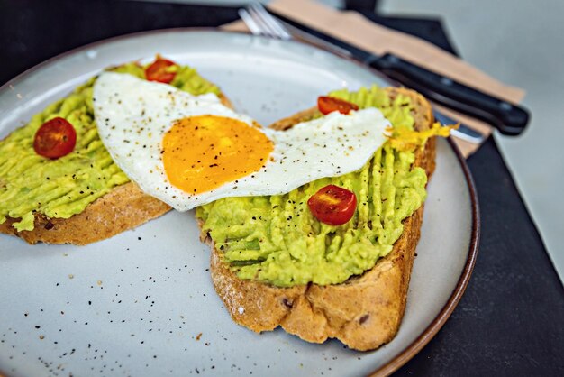 Klassiek ontbijt close-up toast met avocado en zonnig zij-ei