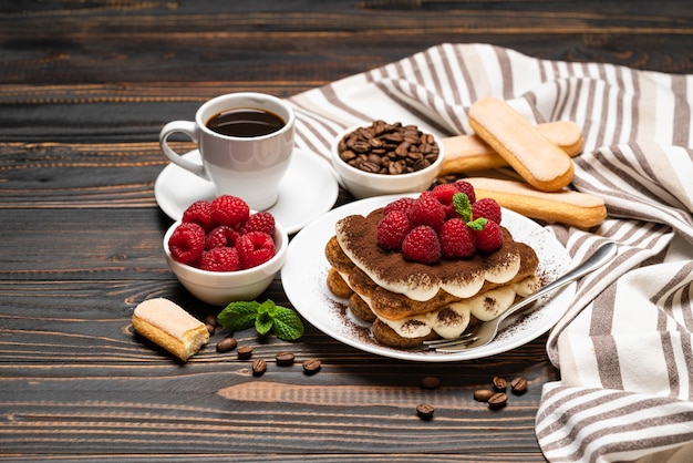 Klassiek tiramisudessert met frambozen en een kopje espresso