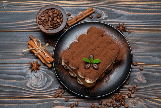 Klassiek tiramisudessert op ceramische plaat op houten achtergrond