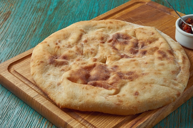 Klassiek Turks brood flatbread geserveerd op een houten bord op een groene tafel. Turks brood