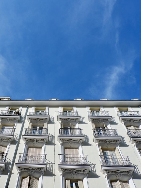 Klassieke beige gevel met elegante metalen balkons en luiken in het centrum van Madrid, Spanje