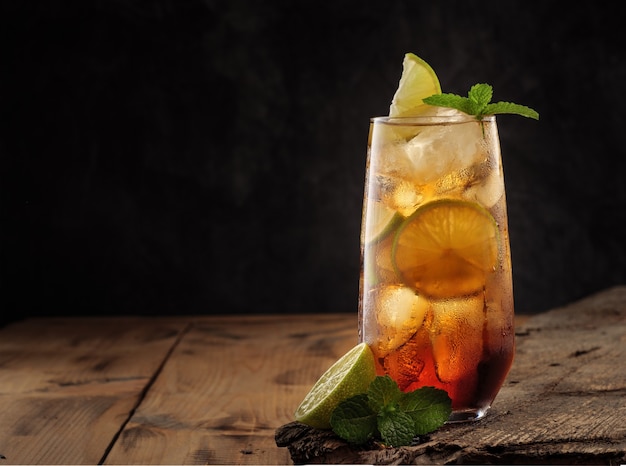 Klassieke cocktail Cuba Libre op een houten tafel, kopieer ruimte.