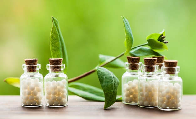 Klassieke homeopathie bolletjes in vintage flessen en natuurbladeren