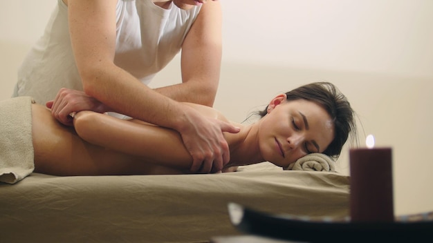 Klassieke massage in de spa salon ontspanningstherapie voor aantrekkelijk jong model