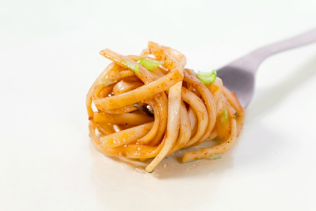 Klassieke pasta met tomatensaus op vork.