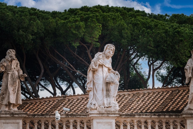 Klassieke standbeelden op het terras van het Vaticaans gebouw te midden van bewakingstechnologie rome