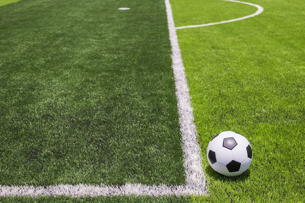 Klassieke voetbalbal op kunstmatig helder en donkergroen gras