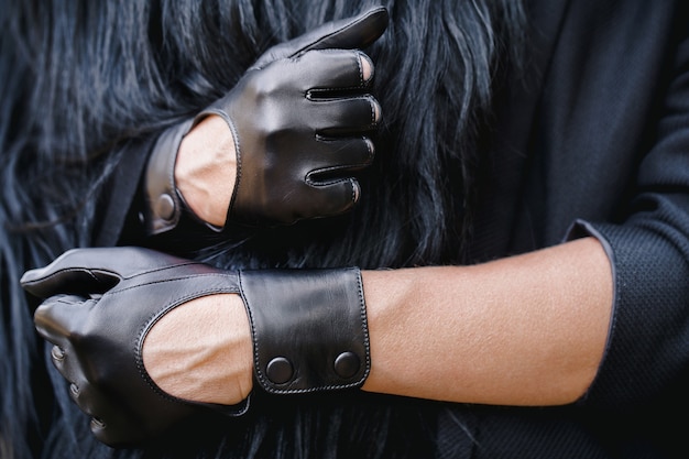 Klassieke zwarte handschoenen aan een vrouwelijke hand.