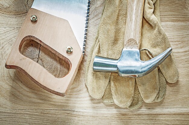 Klauwhamer beschermende handschoenen scherpe handzaag op houten plank bouwconcept