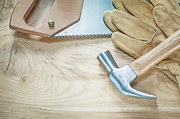 Klauwhamer veiligheidshandschoenen roestvrij ijzerzaag op houten bord bouwconcept