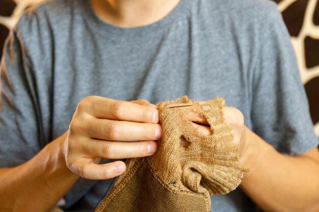 Foto kleding repareren een man is bezig met het naaien huishoudelijke taken selectieve focus