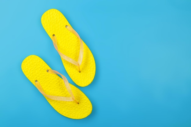 Kleding schoenen en accessoires bovenaanzicht gele paar slippers blauwe achtergrond
