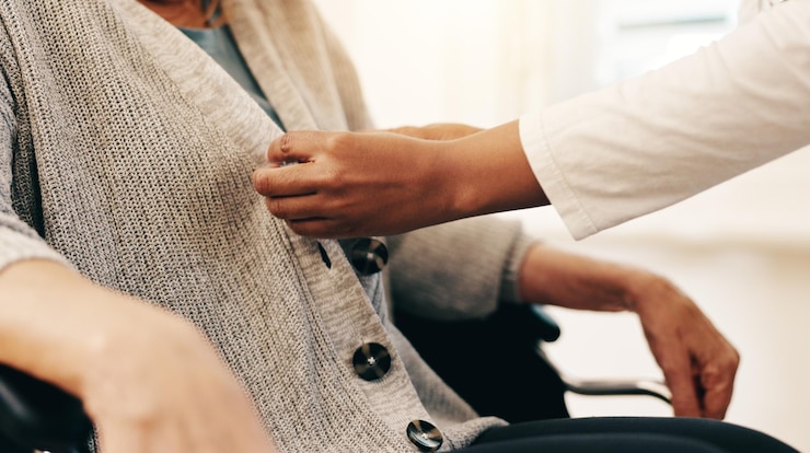 Foto kleding zorgverlener en oudere persoon met een handicap voor hulp, ondersteuning en comfort bij pensionering handen patiënt en verpleegster in close-up voor hulp gezondheid welzijn en vrouw in rolstoel