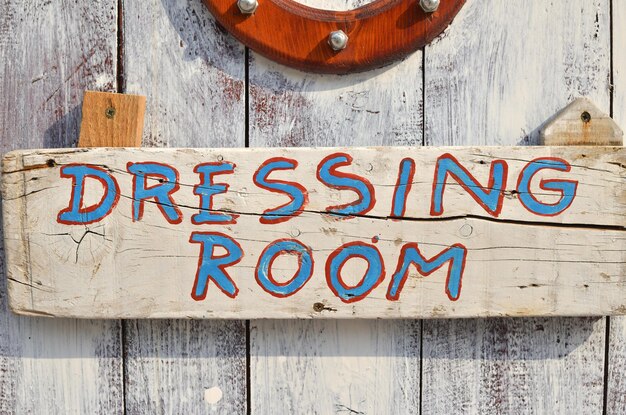 Foto kleedkamer geschreven op een witte houten deur van een strandhut