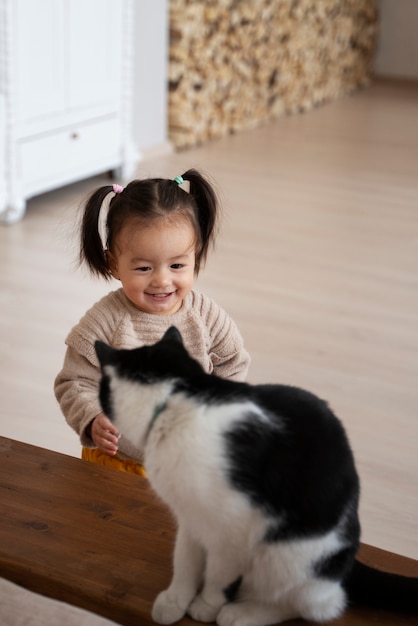 Foto klein aziatisch meisje thuis met haar kat